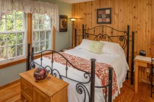1 Schlafzimmer mit einem Bett, einem Schreibtisch und 2 Fenstern in der Unterkunft Cloran Mansion Bed & Breakfast in Galena