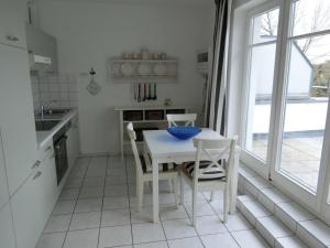 ツィノヴィッツにあるAppartement Residenz Bellevue Usedom 52 DSL WLAN kostenlosの白いキッチン(白いテーブルと椅子付)