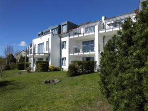 Un gran edificio blanco con un patio delante. en Appartement Residenz Bellevue Usedom Whg 31, en Zinnowitz