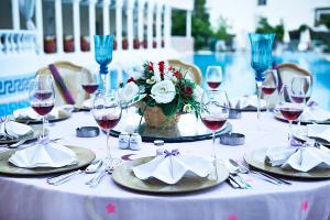 uma mesa com copos de vinho e um vaso de flores em Pashas Princess by Werde Hotels - Adult Only em Kemer