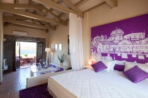 a bedroom with a bed with a painting on the wall at Angelina Boutique Escape in Perdika