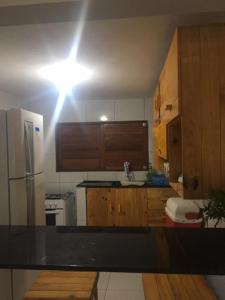 a kitchen with a sink and a refrigerator at Chalé encontro das aguas in Barra do Cunhau