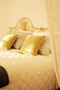 a bed with gold pillows and a gold headboard at 6/4 de Sado in Setúbal