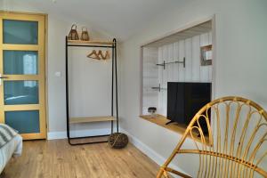 a living room with a television and a chair at Villa l'Estuaire Chambres d'Hôtes in Braud-et-Saint-Louis