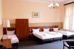 ein Hotelzimmer mit 2 Betten und einem Kronleuchter in der Unterkunft Hotel-Pension Rheingold am Kurfürstendamm in Berlin