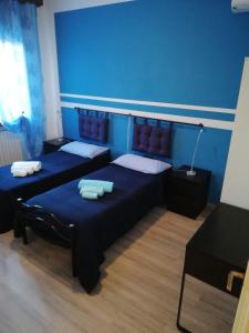 Duas camas num quarto com paredes azuis em B&B La Luce - Casa di Ale em Loreo