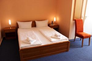 una camera da letto con un letto e due asciugamani di Hotel-Pension Rheingold am Kurfürstendamm a Berlino