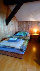 a bed in a room with a wooden wall at Gästehaus Burgwald-Trekking in Mittelsimtshausen