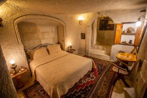 a bedroom with a large bed and a bathroom at Koza Cave Hotel in Goreme