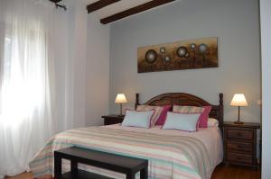 a bedroom with a large bed with pink pillows at Posada Rural La Flor in Las Navas del Marqués