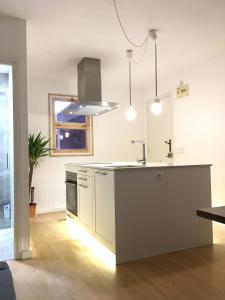 een witte keuken met een wastafel en een fornuis bij Apartamento con WiFi y Aire acondicionado en Pals Playa in Pals