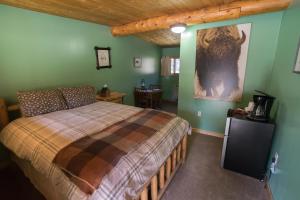 - une chambre avec un lit et des murs verts dans l'établissement Silver Gate Lodging, à Cooke City