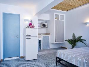 1 dormitorio con 1 cama y cocina con microondas en KALITHEA-HILLS APARTMENT 3, en Koskinou