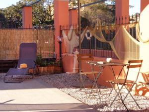 a patio with chairs and a table and a fence at Le Onde in Levanto