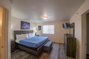 1 dormitorio con 1 cama y TV de pantalla plana en Moab Redcliff Condos en Moab