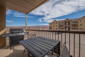 eine Terrasse mit einem Grill und einem Tisch auf dem Balkon in der Unterkunft Moab Redcliff Condos in Moab + 10 Fotos
