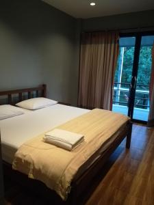 a bedroom with a bed with two towels on it at Water's House in Suratthani