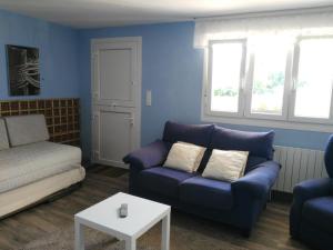 uma sala de estar azul com um sofá e uma mesa em LUR ETXEA em El Valle