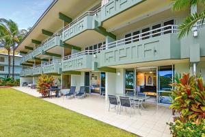 a large building with a patio with a table and chairs at Hibiscus 006 - Hamilton Island in Hamilton Island