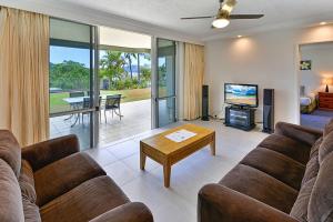 a living room with a couch and a tv at Hibiscus 006 - Hamilton Island in Hamilton Island