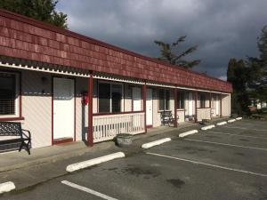 un edificio rojo y blanco con aparcamiento en Tyee Restaurant and Motel, en Coupeville