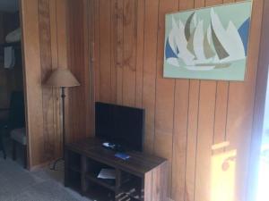 Habitación con TV y mesa con lámpara. en Tyee Restaurant and Motel, en Coupeville