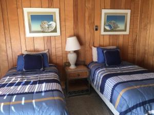a room with two beds and a table with a lamp at Tyee Restaurant and Motel in Coupeville