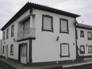 Edificio blanco con persianas negras y balcón en Hotel Branco II, en Praia da Vitória
