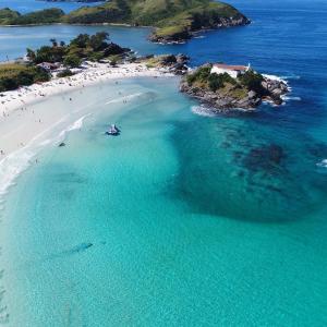 uma vista aérea de uma praia com pessoas na água em Cobertura em cabo frio em Cabo Frio