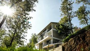 a building with the sun shining through the trees at Falcon Crest in Vagamon