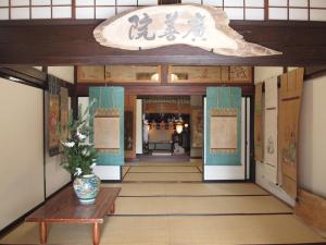 a hallway of a building with a vase on a table at Oshi Ryokan in Nagano