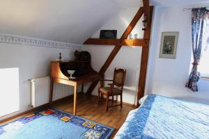 a bedroom with a bed and a desk and a chair at Pojezierze Drawskie Agroturystyka Greanna in Ostrowice