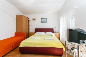 a bedroom with a bed and a flat screen tv at Apartments Posavec in Pinezici