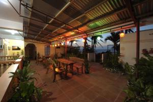 un patio al aire libre con mesa, sillas y luces en Batanes Seaside Lodge & Restaurant, en Basco