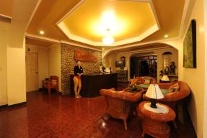 una mujer parada en una habitación con una mesa y sillas en Batanes Seaside Lodge & Restaurant, en Basco