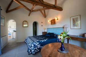 a bedroom with a bed and a wooden table at La Source, Beynac, Dordogne in Beynac-et-Cazenac