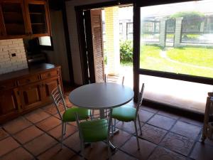 un tavolo e delle sedie in una cucina con una finestra di Residencial Plataforma -100m do Mar -Tramandai-Centro a Tramandaí