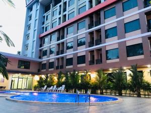 a large building with a large swimming pool in front of it at ATK Garden Hills in Hat Yai