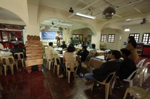 grupa ludzi siedzących przy stolikach w restauracji w obiekcie Batanes Seaside Lodge & Restaurant w Basco