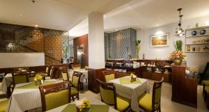 Un restaurante con mesas y sillas y un bar. en Cherry Central Hotel- Near Opera House, en Ho Chi Minh