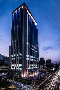 a tall building with blue windows on a city street at The Place Taipei in Taipei