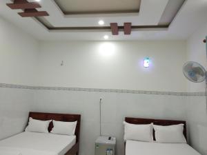 dos camas sentadas una al lado de la otra en una habitación en Khách sạn Mộng An, en Vĩnh Hy