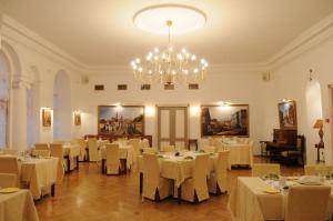 a dining room with white tables and a chandelier at St.Olav Hotel in Tallinn