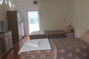 um quarto de hotel com duas camas e uma televisão em Mint Guesthouse em Ko Tao