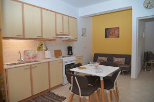 uma cozinha com mesa e cadeiras e uma cozinha com lavatório em River house fully renovated & equipped 10' from DT em Potamós