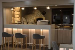 a kitchen with stools at a counter with a bed at Hotel Pomorski in Bydgoszcz