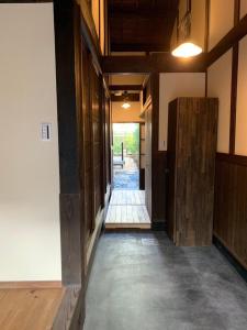 近江の町家 門 في أوميهاتشيمان: غرفة فارغة مع مدخل مع أبواب خشبية