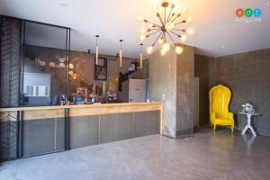 a kitchen with a bar and a yellow chair at PJ Loft Hotel in Ban Khok Krathin