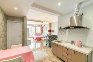 重庆Xiao Yu Residential Apartment Near Jiefangbei and Hongya Cave的带粉红色台面的厨房和客厅