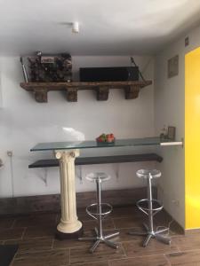 a bar with two stools and a table with a television at WOHLFÜHLOASE - Zimmer, Appartment - im Herzen STARNBERGS in Starnberg